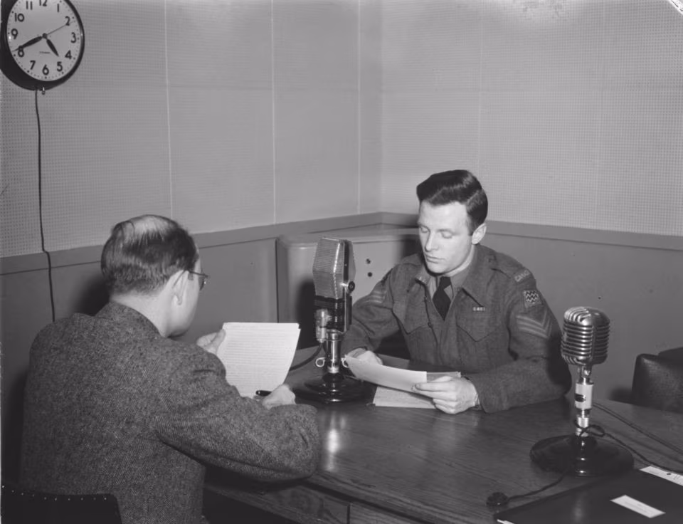 Dos comentaristas, un militar y un civil, animan un noticiario en onda corta en el estudio de la C.B.C. (Radio-Canadá) situado en la calle Crescent de Montreal, 19 de febrero de 1945. Fuente: Conrad Poirier, Biblioteca y Archivos Nacionales de Quebec.