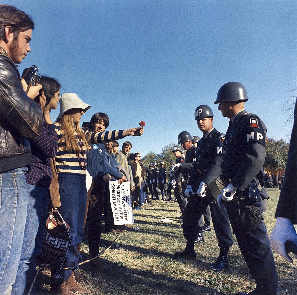 Una manifestante ofrece una flor a la policía militar en una protesta contra la guerra de Vietnam en Arlington, Virginia, Estados Unidos.