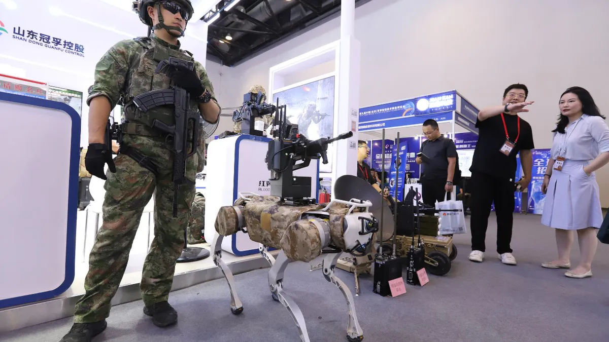 Visitantes observan un perro robot de combate durante la 9ª Exposición de Tecnología Militar Inteligente de China (Pekín) en el Centro Nacional de Convenciones de China en Pekín. Créditos: Guo Haipeng/VCG