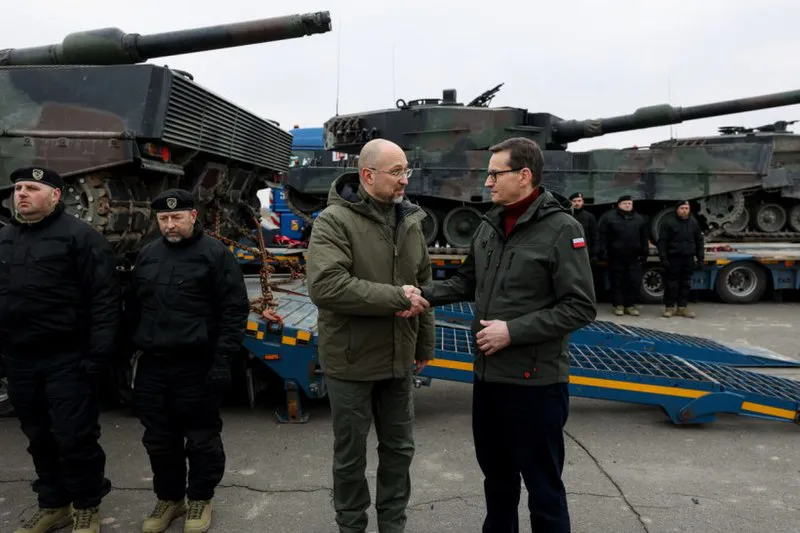 Los primeros ministros de Ucrania y Polonia se dan la mano cerca de los tanques Leopard 2 proporcionados por Polonia a Ucrania. Fuente: Kmu.gov.ua