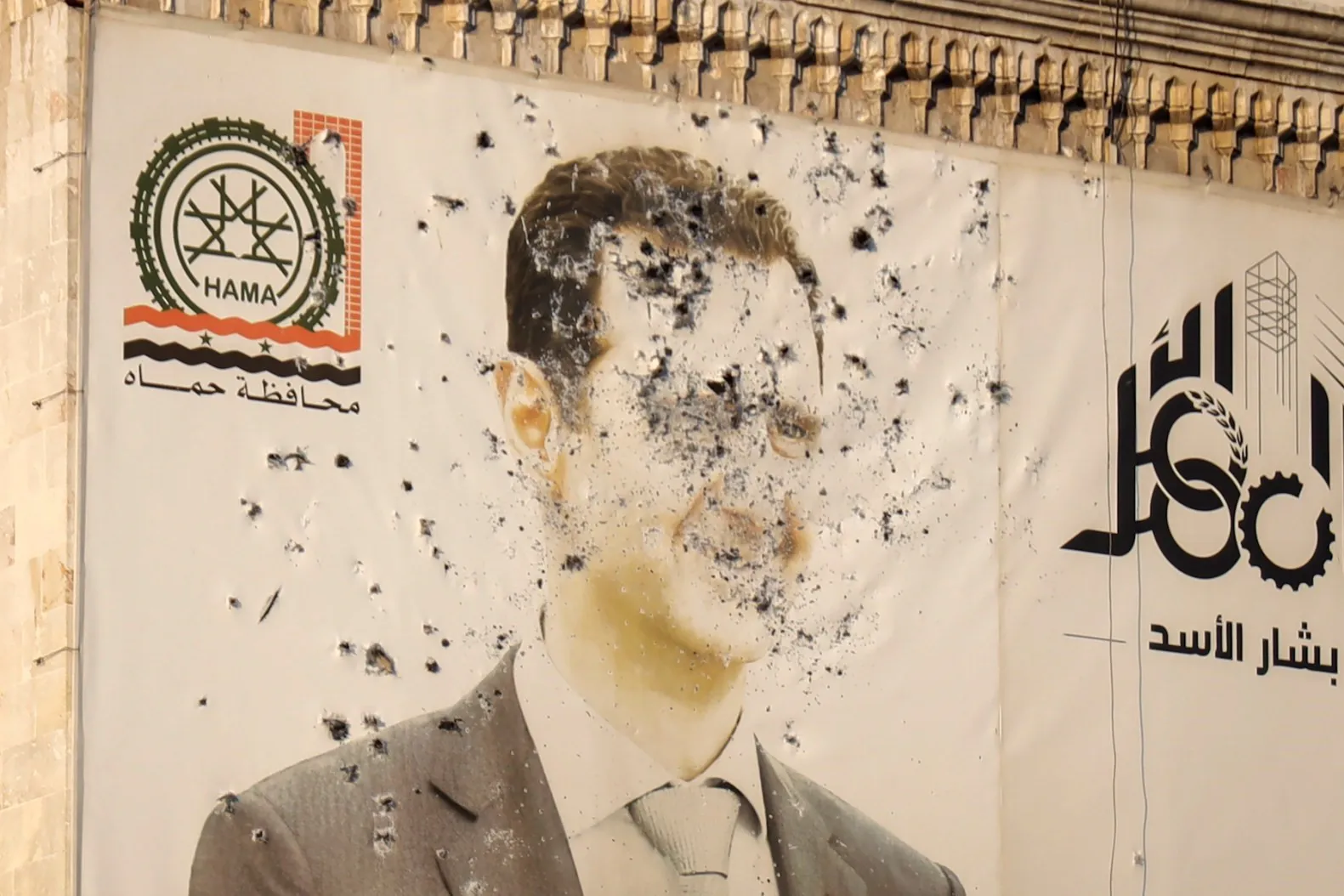 Una imagen del presidente sirio Bashar al-Assad, acribillada a balazos, aparece en la fachada de una oficina del gobierno provincial tras la toma de Hama (Siria) por los rebeldes el 6 de diciembre de 2024. Créditos: AP