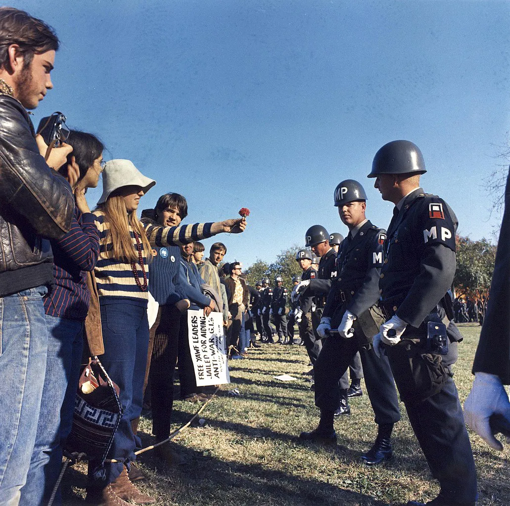 Una manifestante ofrece una flor a la policía militar en una protesta contra la guerra de Vietnam en Arlington, Virginia, Estados Unidos.